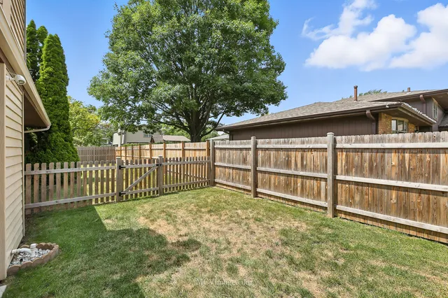 a view of a backyard with a small pool and wooden fence