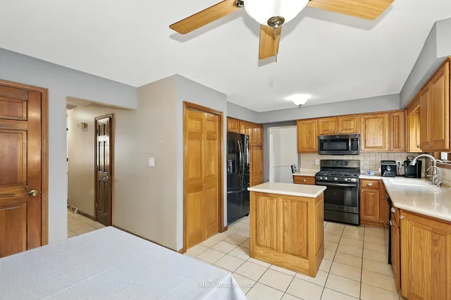 a kitchen with stainless steel appliances granite countertop a refrigerator and a stove top oven