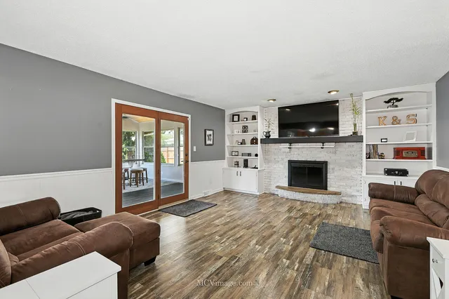 a living room with furniture a fireplace and a flat screen tv