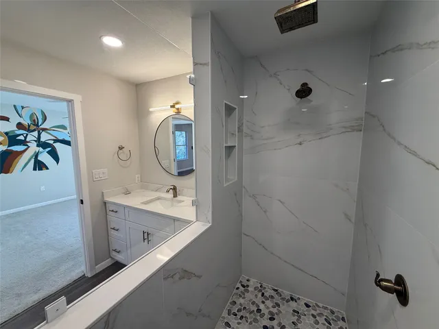 a bathroom with a sink a mirror and a shower