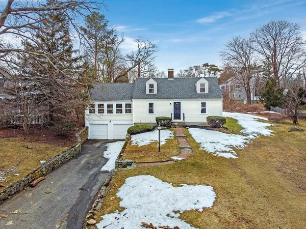 a view of a brick house with a yard covered with snow in front of it