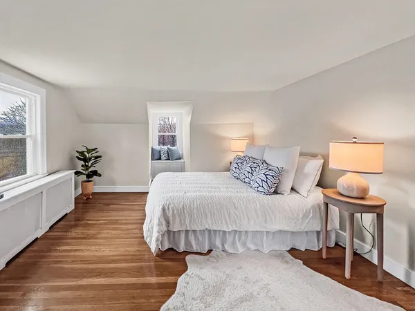 a spacious bedroom with a bed and wooden floor