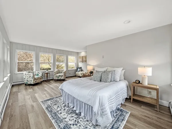 a spacious bedroom with a bed couch and a window