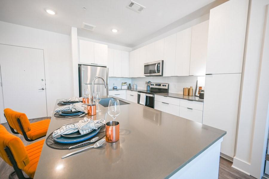 72 Milton Avenue Southeast, Unit 3407 Atlanta, GA 30315 - Photo 3 of 27 a kitchen with stainless steel appliances kitchen island granite countertop a stove and white cabinets