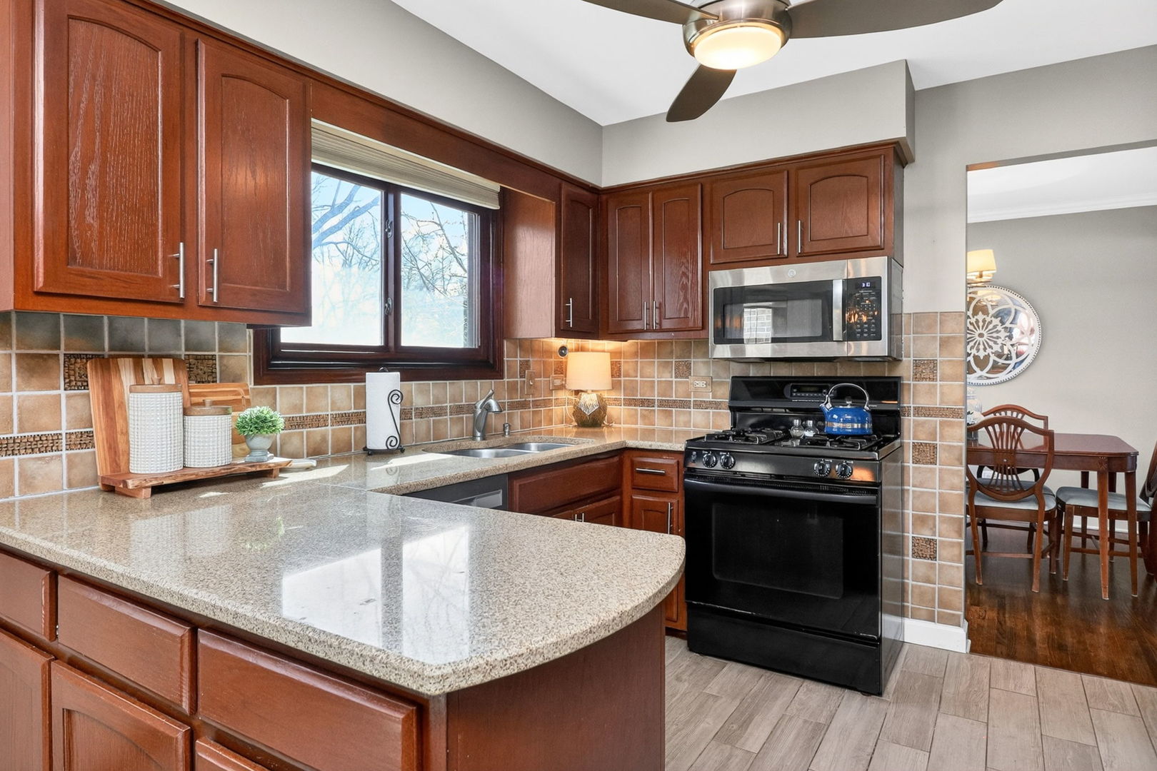 2123 Green Valley Road Darien, IL 60561 - Photo 6 of 30 a kitchen with stainless steel appliances granite countertop a stove a sink dishwasher and a microwave oven with wooden cabinets