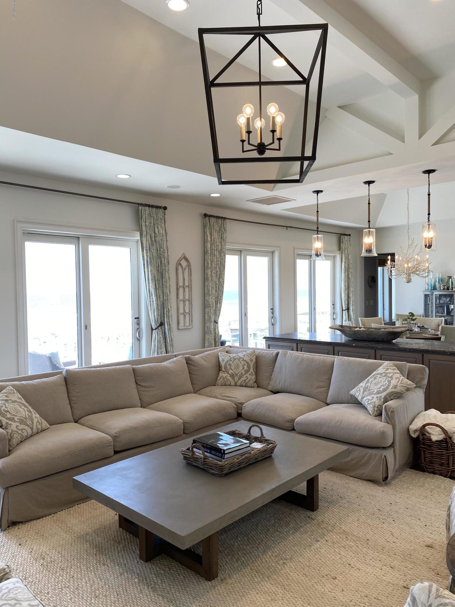 264 Beach Road North Wilmington, NC 28411 - Photo 15 of 51 Large living area with wall of doors and windows looking out to the clear, blue ocean.