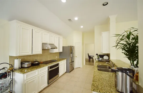 a kitchen with a refrigerator and a stove top oven
