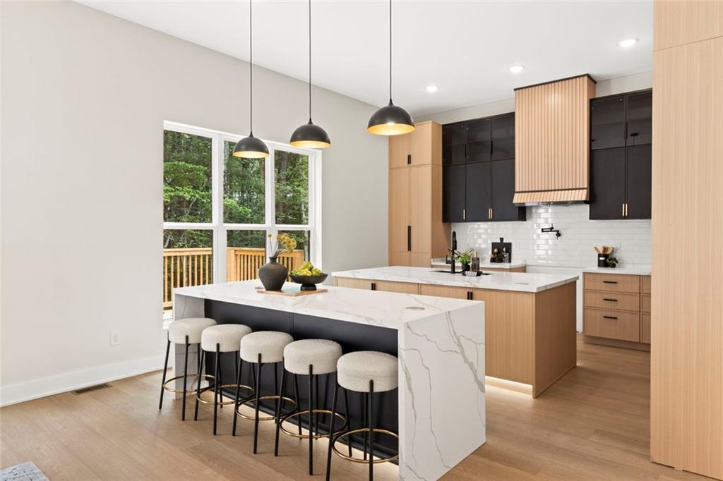 7066 Bells Way Fairburn, GA 30213 - Photo 19 of 64 a large kitchen with kitchen island a dining table and chairs