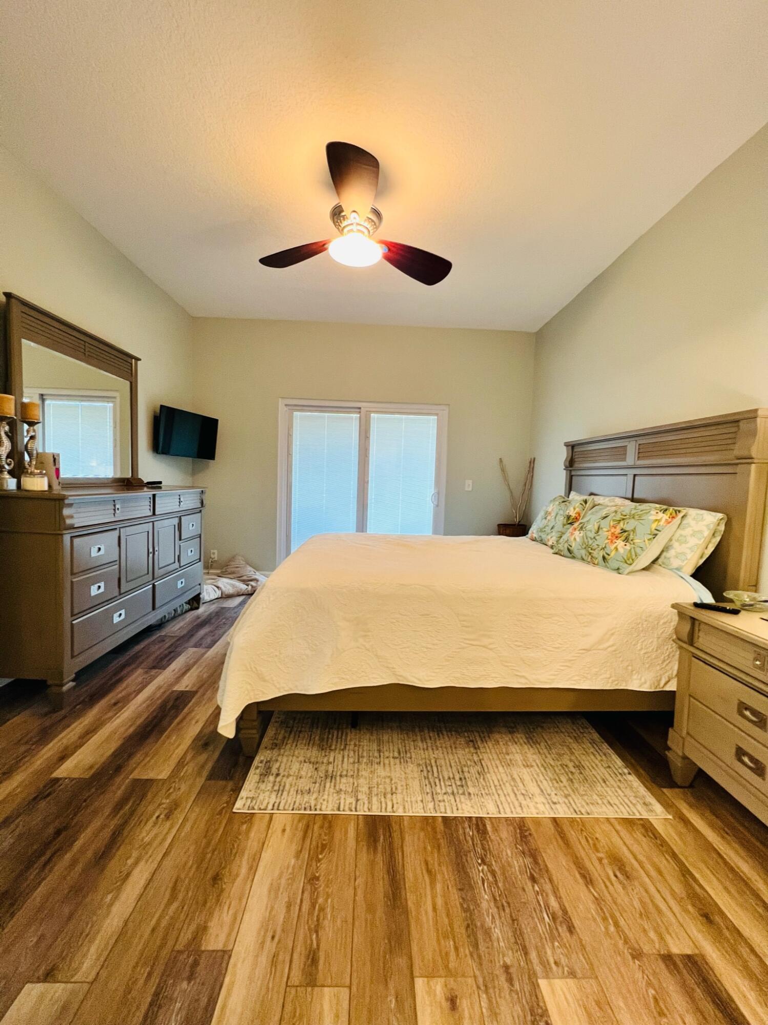 115 Lighthouse Circle, Unit B Tequesta, FL 33469 - Photo 12 of 19 a bedroom with a bed and wooden floor