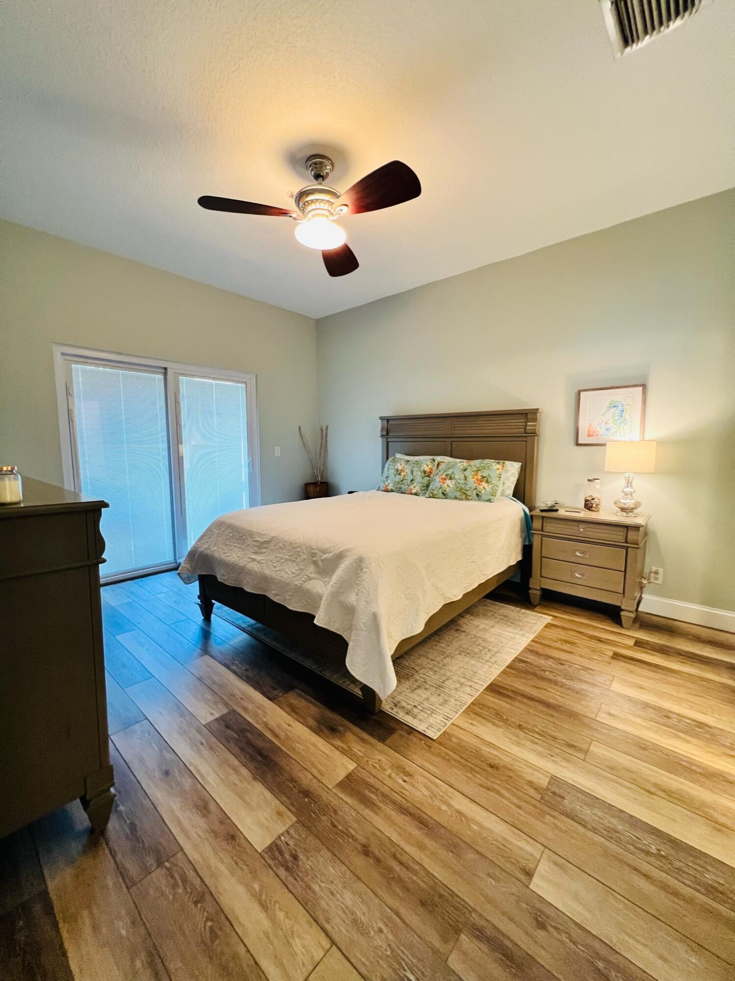 115 Lighthouse Circle, Unit B Tequesta, FL 33469 - Photo 13 of 19 a bedroom with a bed and a chandelier