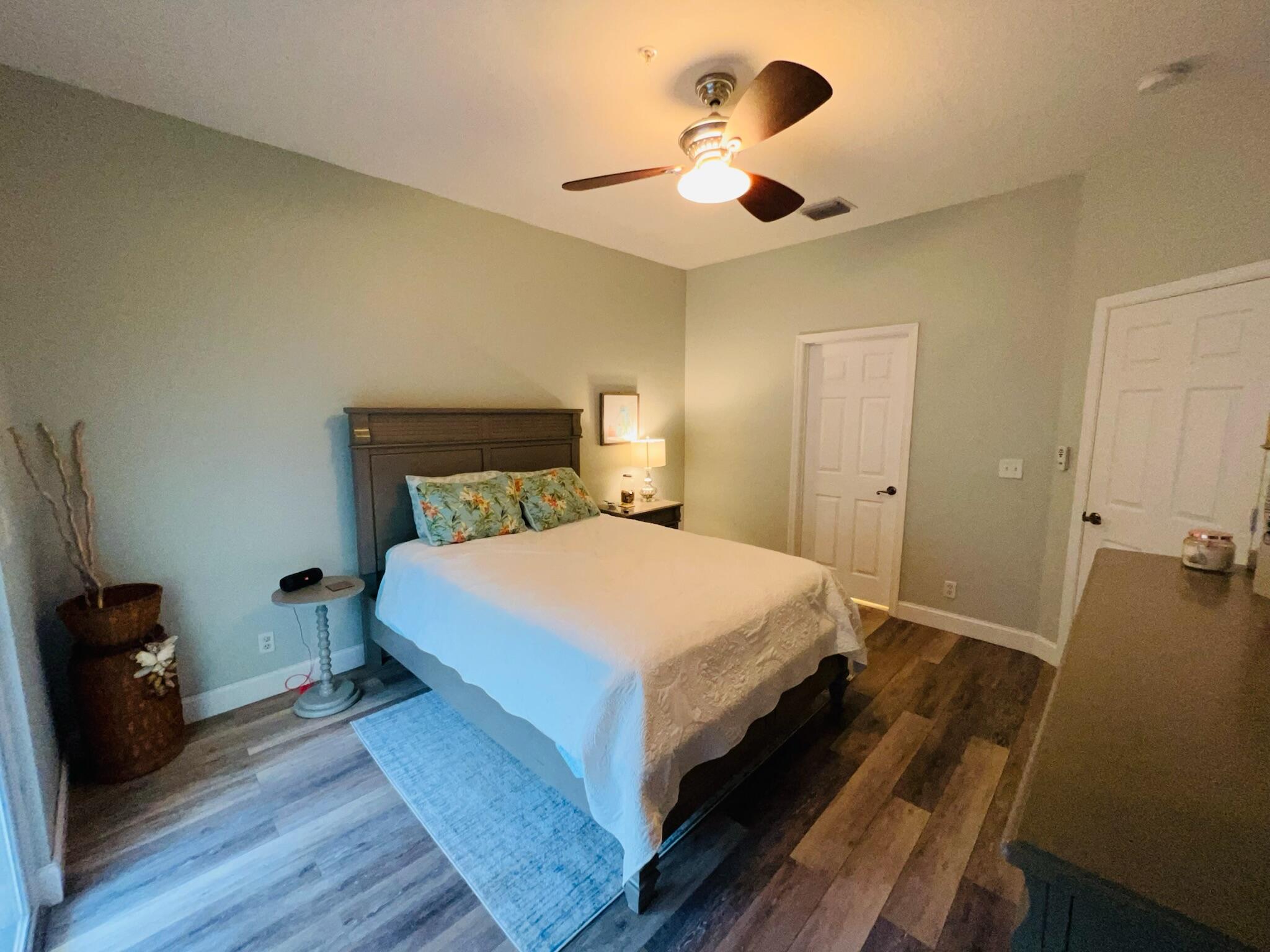 115 Lighthouse Circle, Unit B Tequesta, FL 33469 - Photo 14 of 19 a bedroom with a bed and a chandelier