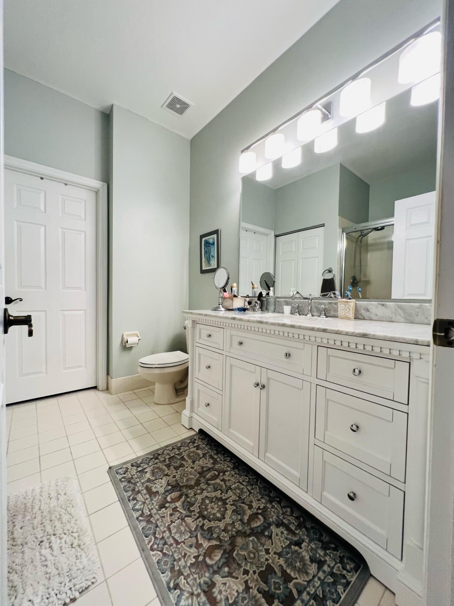 115 Lighthouse Circle, Unit B Tequesta, FL 33469 - Photo 15 of 19 a bathroom with a double vanity sink and a mirror