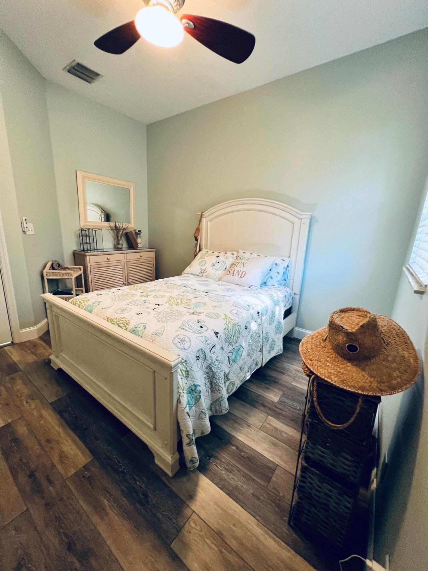 115 Lighthouse Circle, Unit B Tequesta, FL 33469 - Photo 17 of 19 a bedroom with bed and a chandelier