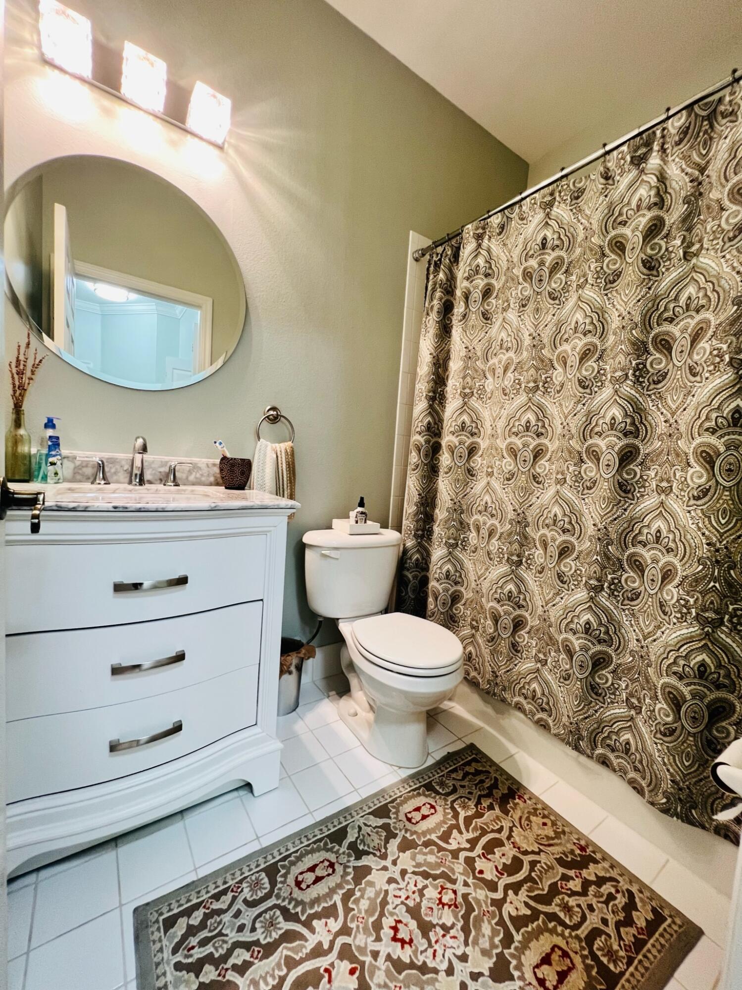 115 Lighthouse Circle, Unit B Tequesta, FL 33469 - Photo 18 of 19 a bathroom with a toilet sink and mirror