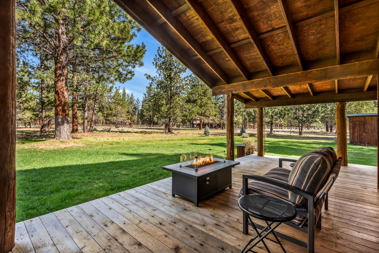 69269 Crooked Horseshoe Road Sisters, OR 97759 - Photo 20 of 43 a view of a patio with table and chairs with wooden floor and fence