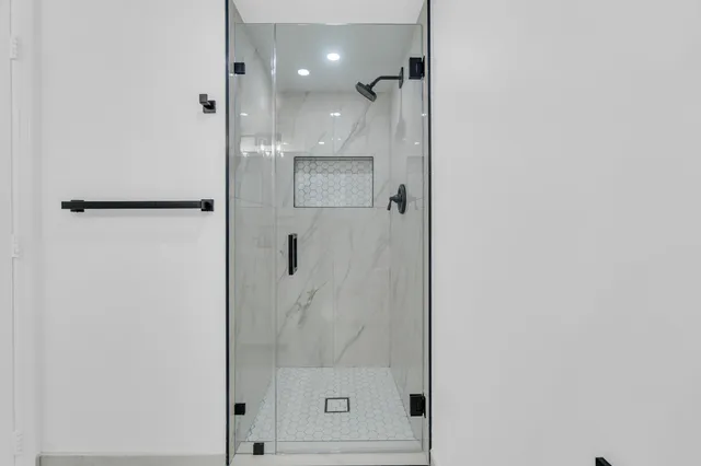 an empty room with wooden floor ceiling fan and windows