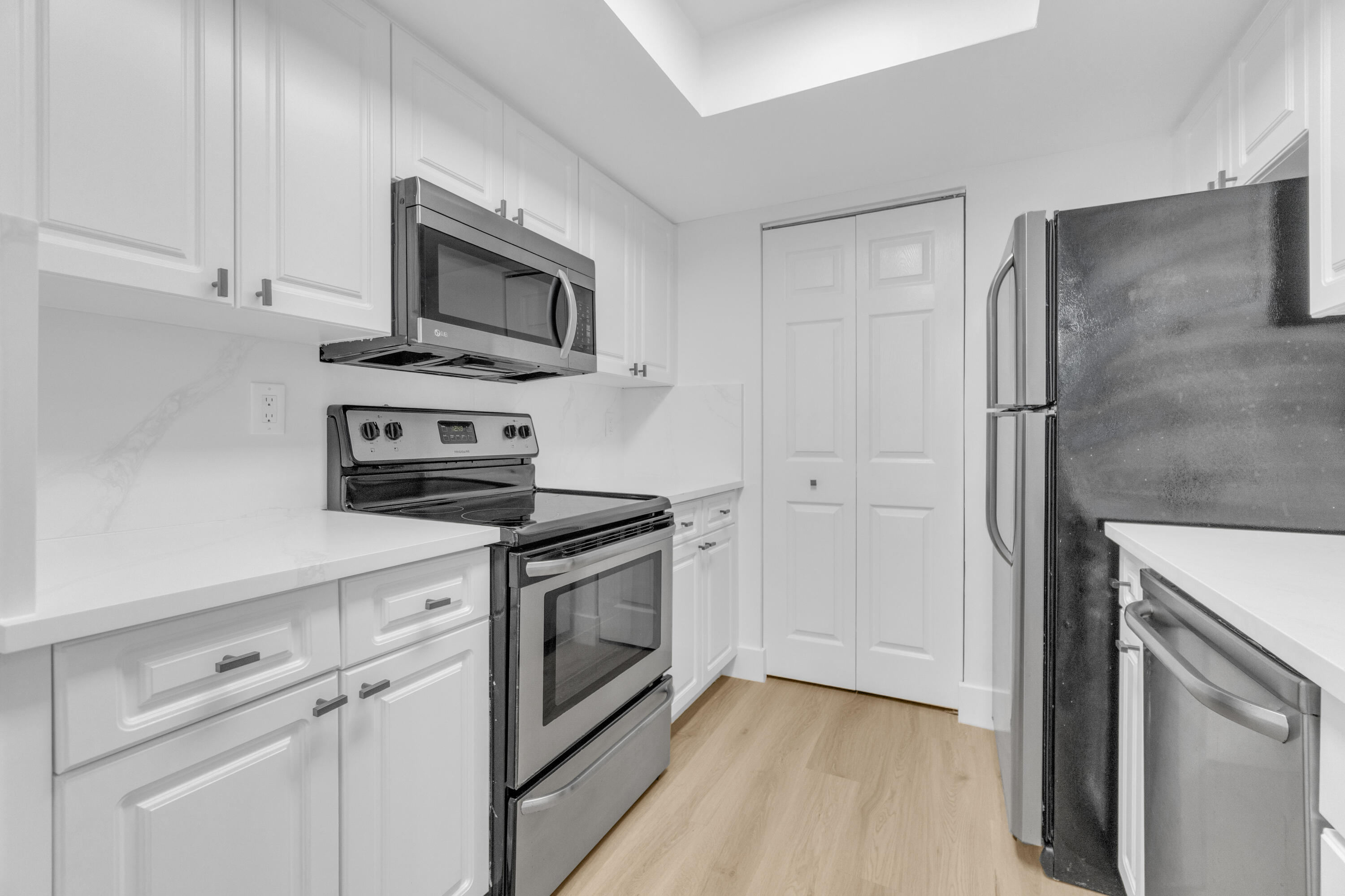 400 Crestwood Court North, Unit 420 Royal Palm Beach, FL 33411 - Photo 8 of 44 a kitchen with stainless steel appliances white cabinets and a stove top oven