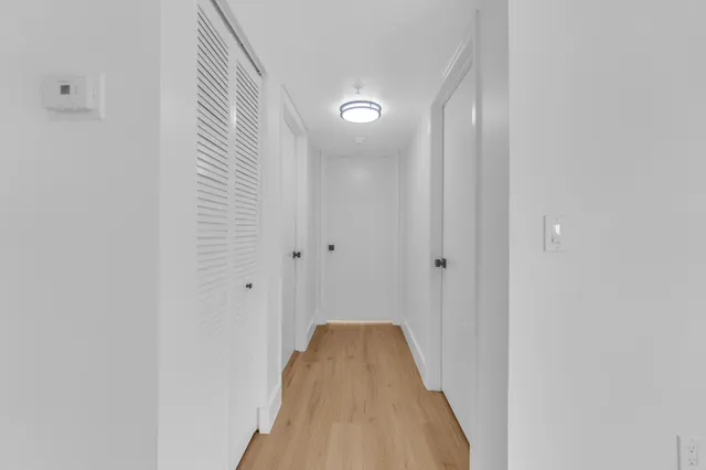 a view of empty room with wooden floor