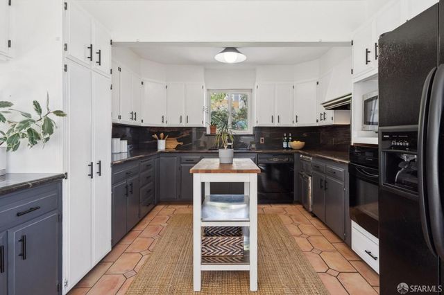 a kitchen with granite countertop a refrigerator stove and sink