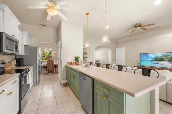 a kitchen with a sink a counter top space appliances and cabinets