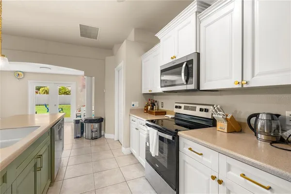 a kitchen with stainless steel appliances a stove a sink a stove a microwave a counter top space and cabinets