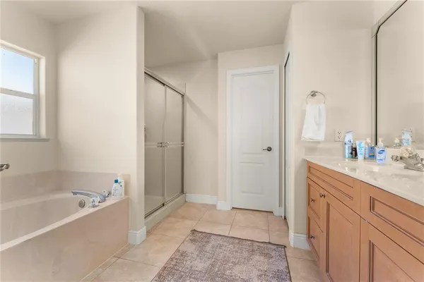 a spacious bathroom with a tub sink and mirror