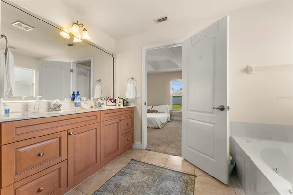 a spacious bathroom with a tub sink and a mirror