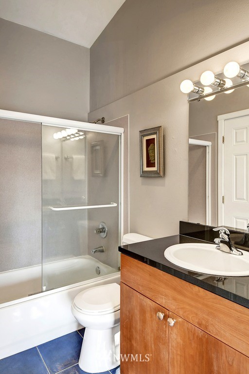 3224 21st Avenue West, Unit B Seattle, WA 98199 - Photo 11 of 17 a bathroom with a granite countertop sink mirror vanity and toilet