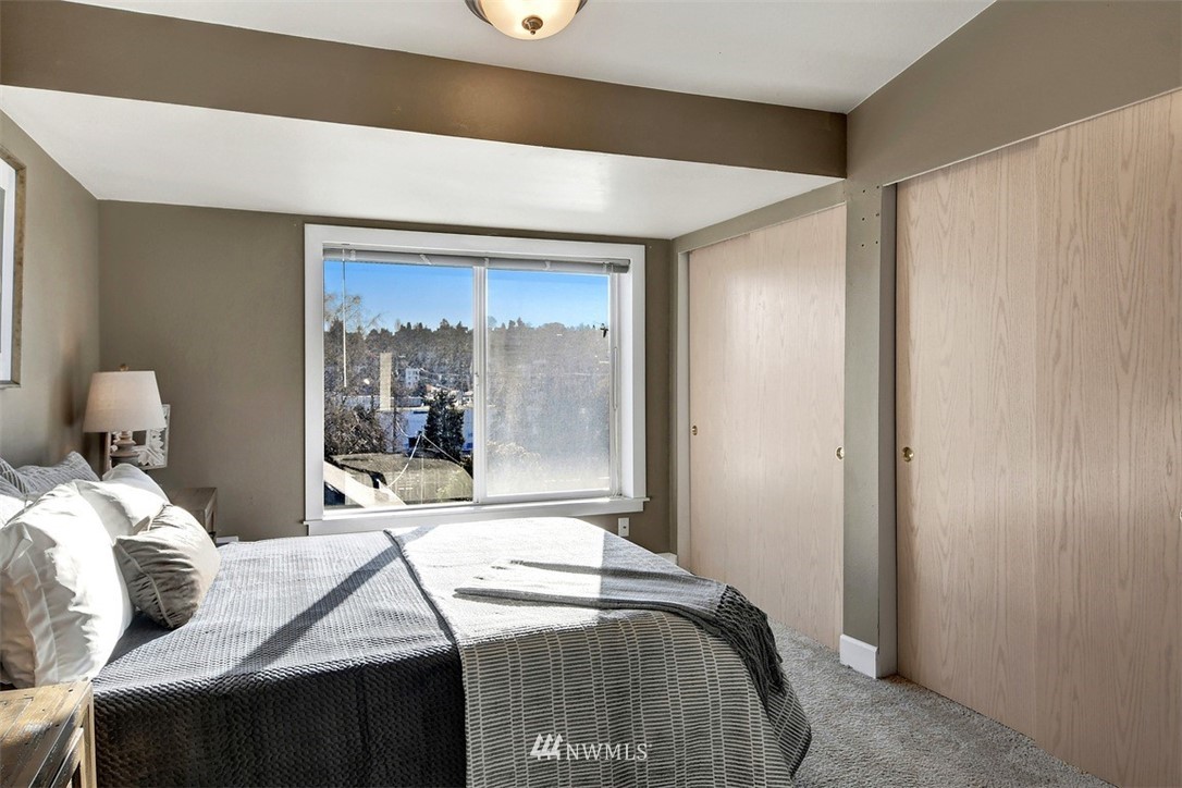 3224 21st Avenue West, Unit B Seattle, WA 98199 - Photo 13 of 17 a bedroom with a bed and a mirror