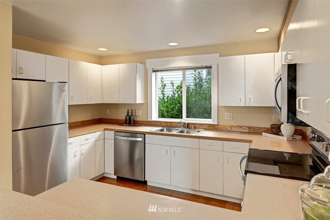 3224 21st Avenue West, Unit B Seattle, WA 98199 - Photo 4 of 17 a kitchen with a sink a refrigerator and cabinets