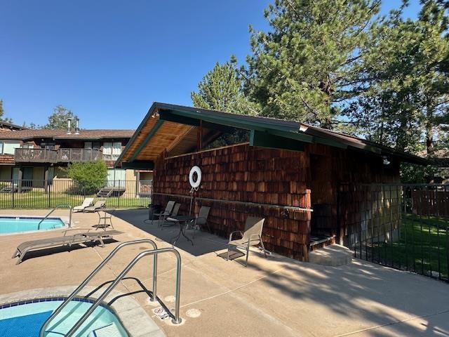 3199 Chateau Road, Unit 17 Mammoth Lakes, CA 93546 - Photo 17 of 23 a view of a patio with table and chairs under an umbrella with a large tree