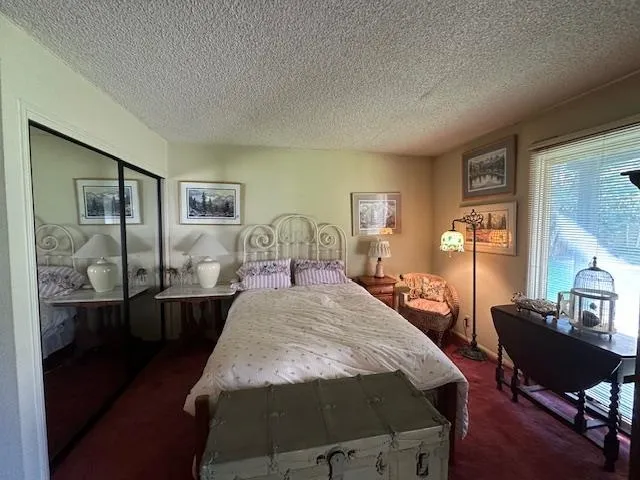 a bed room with a bed window and table chair