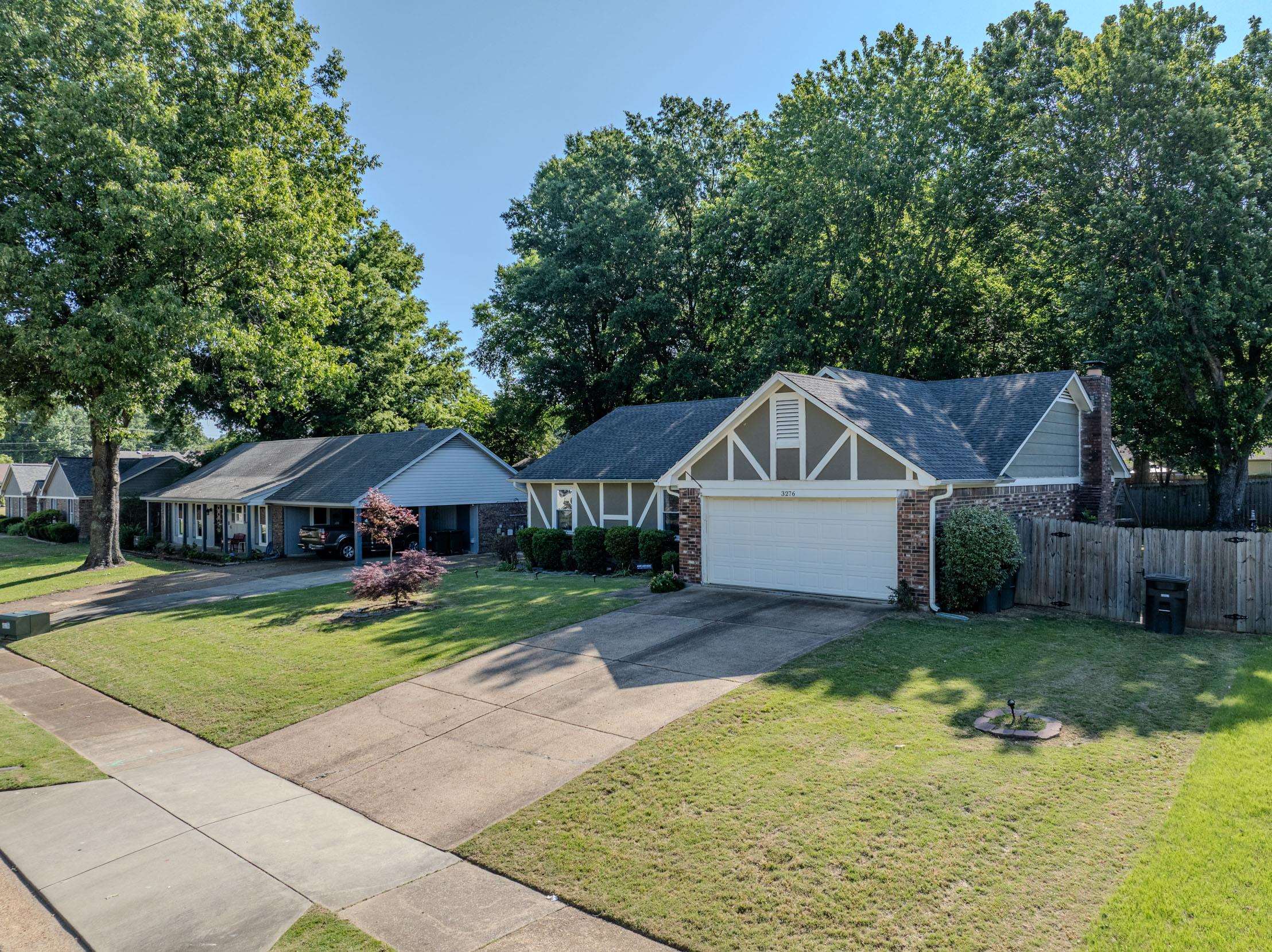 3276 Altruria Road Bartlett, TN 38134 - Photo 24 of 30 Single-story residence featuring a two-car garage, brick and siding exterior, front yard with mature trees, and a concrete driveway