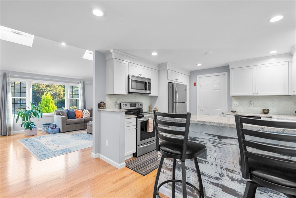 83 Dolar Davis Road Barnstable, MA 02632 - Photo 18 of 36 a kitchen with stainless steel appliances kitchen island granite countertop a stove a refrigerator a sink a stove and white cabinets with wooden floor