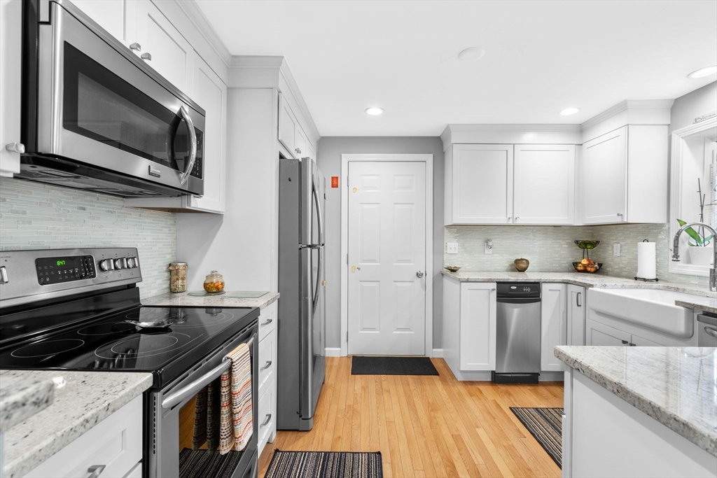 83 Dolar Davis Road Barnstable, MA 02632 - Photo 3 of 36 a kitchen with stainless steel appliances a sink dishwasher a stove top oven a refrigerator with grey cabinets and wooden floor