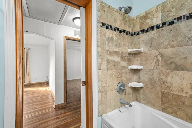 an empty room with windows and fan