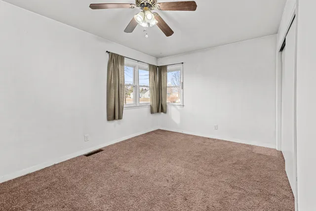 an empty room with a fan and a fan