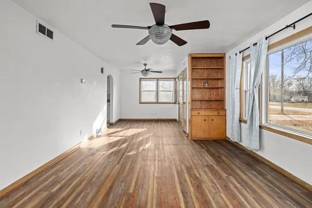 a view of empty room with wooden floor and window