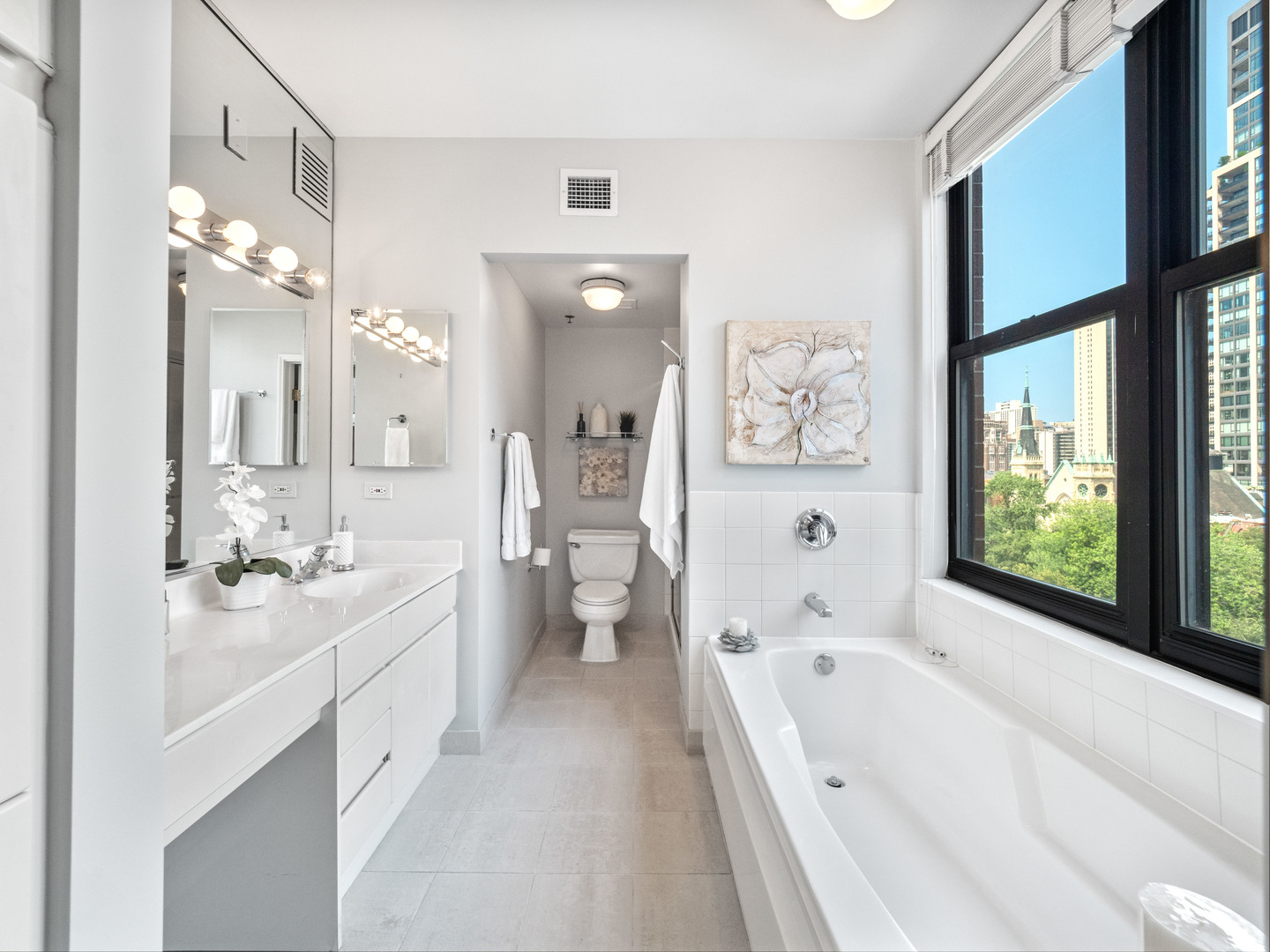 55 West Delaware Place, Unit 921 Chicago, IL 60610 - Photo 16 of 33 a large white bathroom with a large tub sink shower and mirror