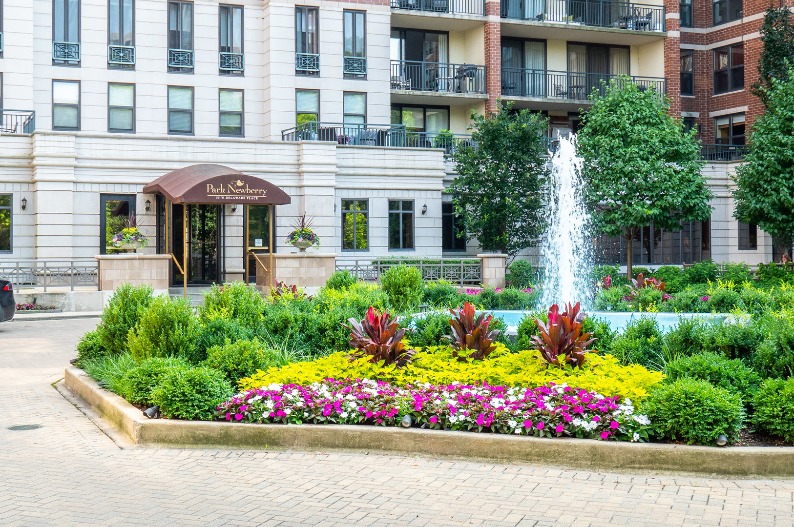 55 West Delaware Place, Unit 921 Chicago, IL 60610 - Photo 29 of 33 a front view of building and flowers and covered with wooden fence
