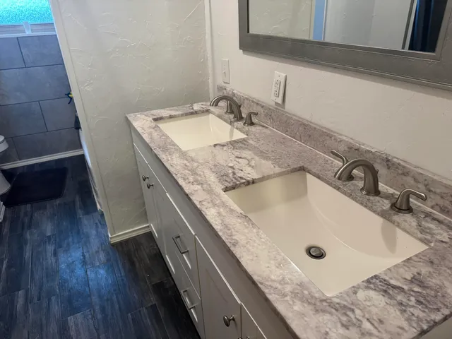 a bathroom with a granite countertop sink and a mirror