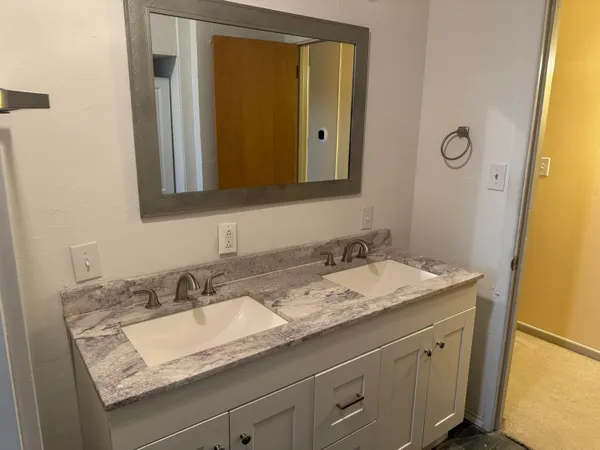 a bathroom with a granite countertop sink and a mirror