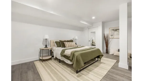 a spacious bedroom with a bed and a wooden floor