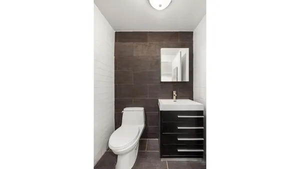 a bathroom with a toilet a sink a mirror and vanity