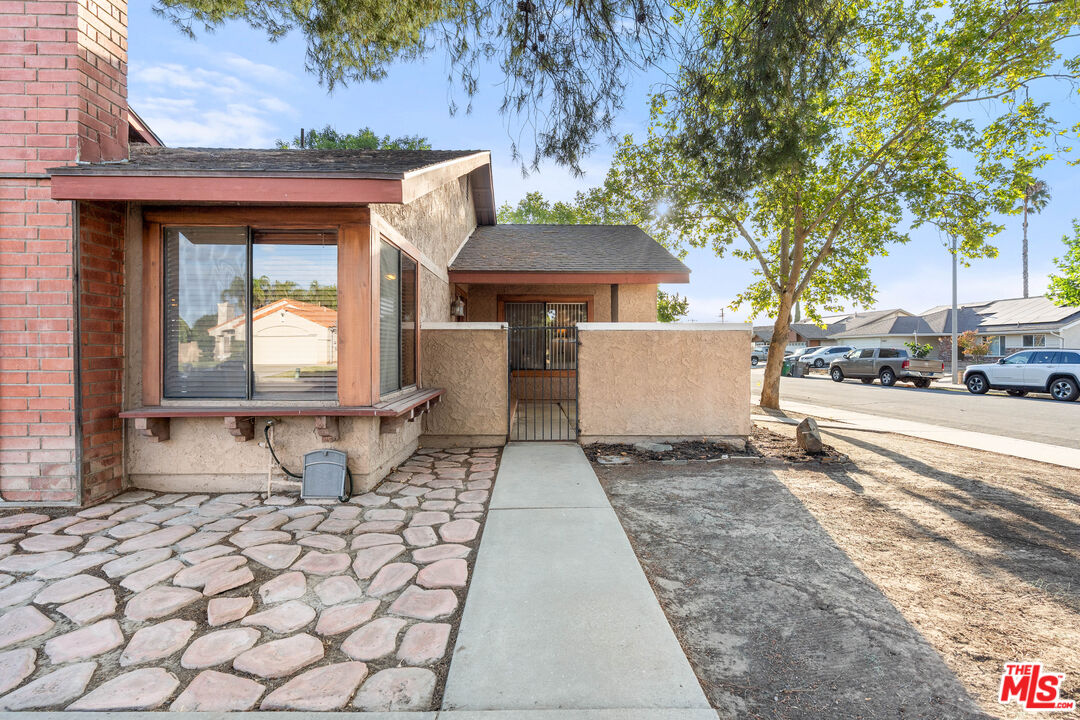 29357 Reading Road Menifee, CA 92586 - Photo 34 of 46 a view of a brick house with a bench next to a road