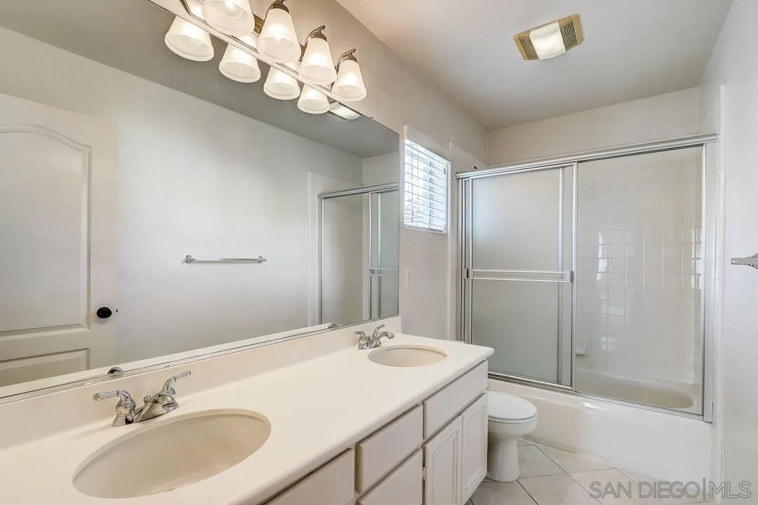 7134 Pintail Drive Carlsbad, CA 92011 - Photo 13 of 30 a bathroom with a sink toilet a mirror and shower