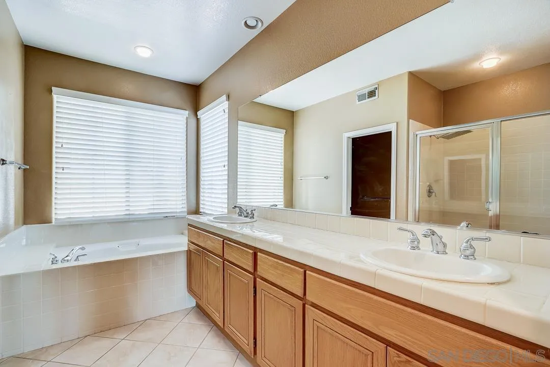 7134 Pintail Drive Carlsbad, CA 92011 - Photo 19 of 30 a bathroom with a granite countertop sink and a bathtub