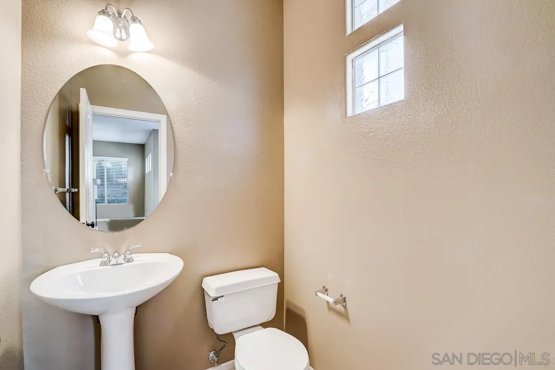 7134 Pintail Drive Carlsbad, CA 92011 - Photo 20 of 30 a bathroom with a toilet a sink and mirror