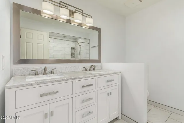 a bathroom with a granite countertop sink vanity and mirror