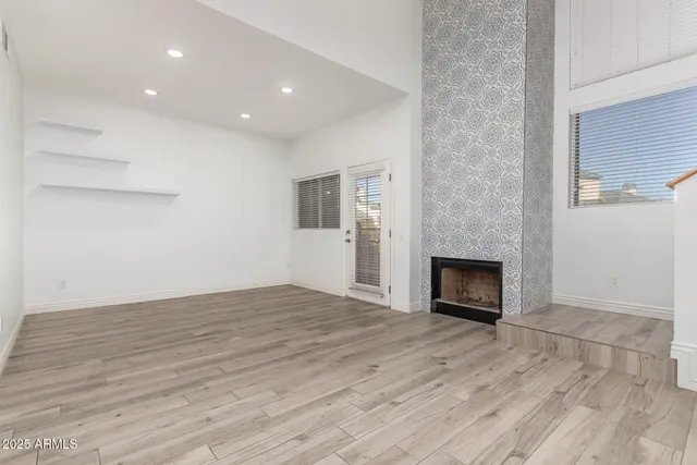 a view of empty room with wooden floor and fireplace